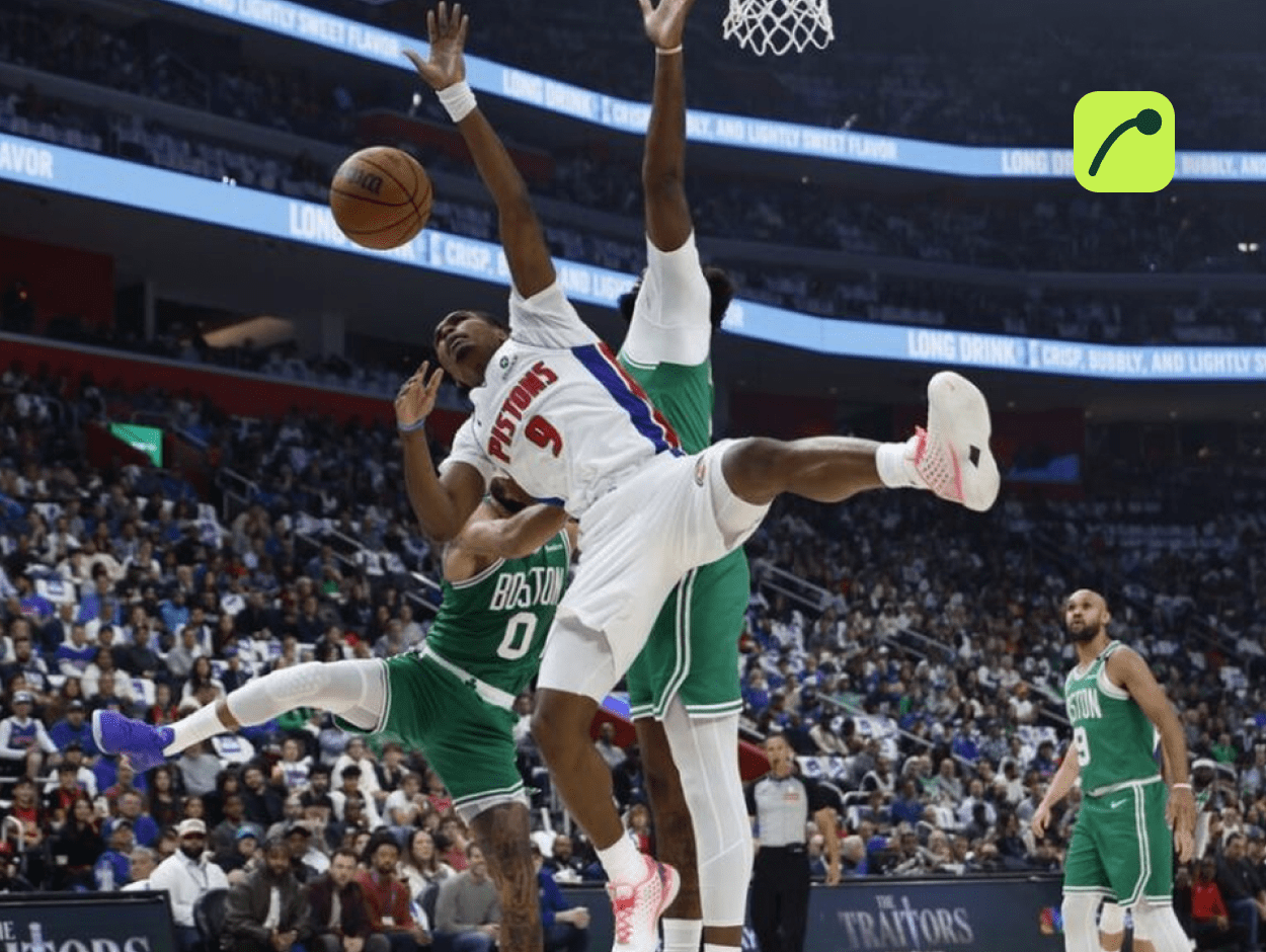 Detroit Pistons player going up for a shot against Boston Celtics defenders